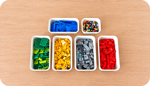 LEGO-klodser sorteret efter farve i små beholdere